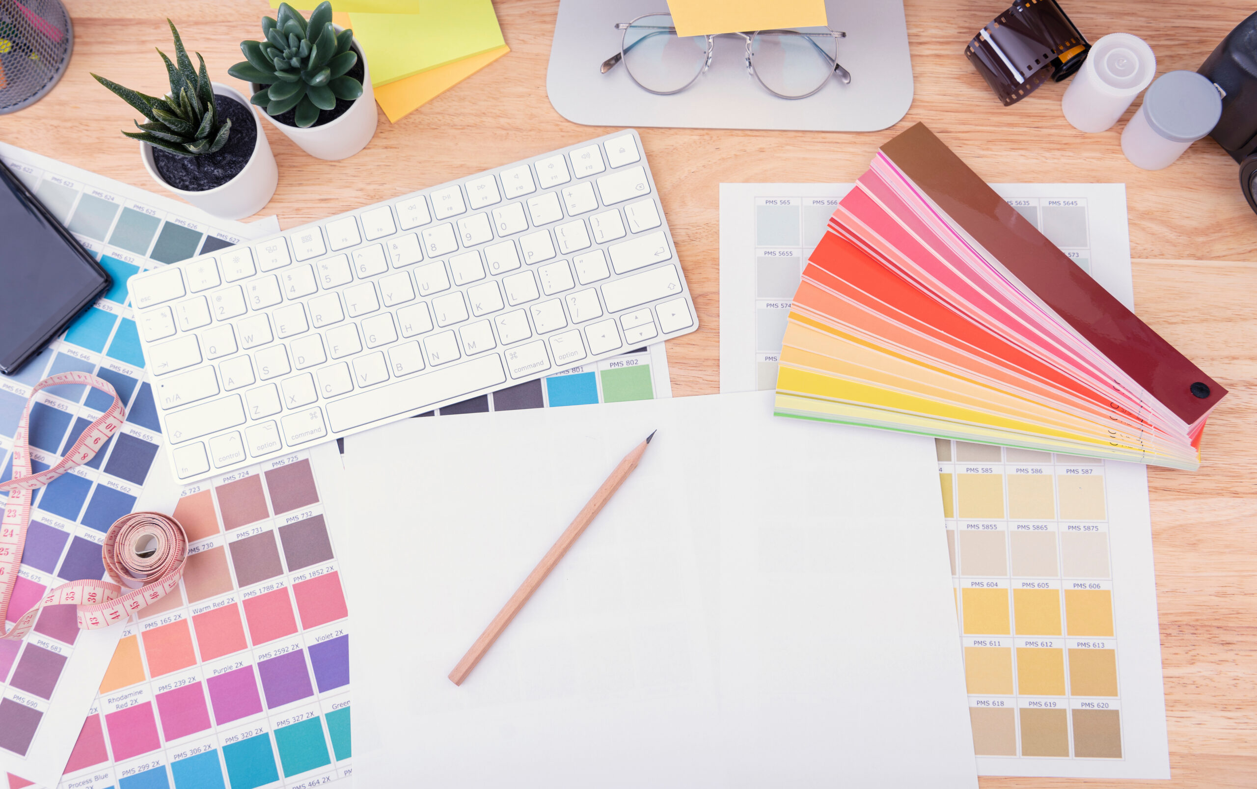 Equipment for graphic designer artist drawing on paper work and colour chart his work at desk in office.